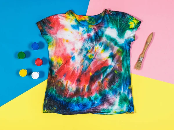 Pinte, escove e amarre a camiseta de tinta em um fundo de três cores. Depósito plano . — Fotografia de Stock