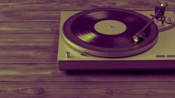 Egy színes kép egy bakelit lemezjátszóról, amin a lemez egy fa asztalra van szerelve.. — Stock Fotó
