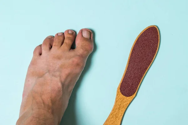 The man\'s left foot and a device for removing rough skin.