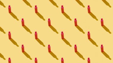 Sarı arka plandaki kırmızı plastik şişelerin arka planı. Kusursuz..