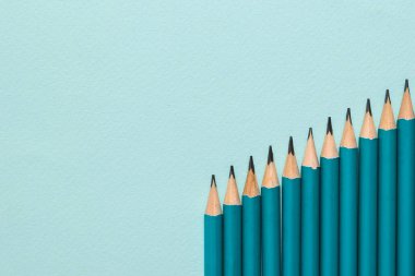 Mavi arka planda bir yığın içinde bir kaç grafit kalem..