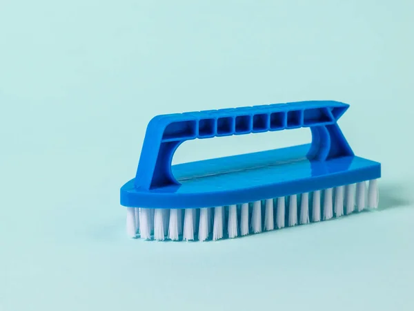 Blue brush with white bristles for cleaning on a blue background. — Stock Photo, Image