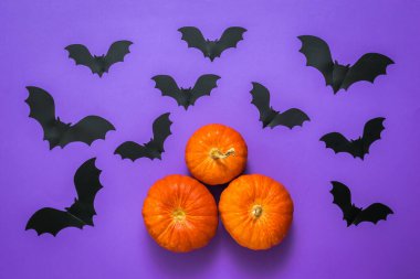 Üç balkabağı ve leylak arka planda çok sayıda yarasa..