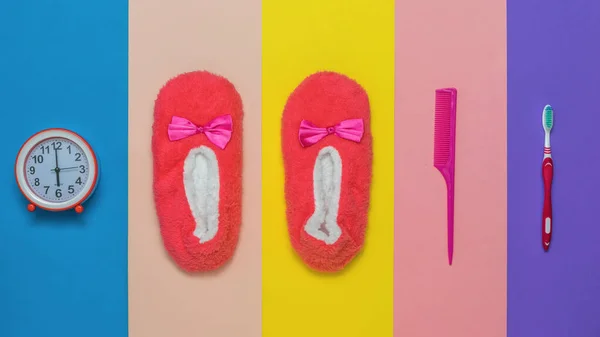 Zapatillas, peine, reloj y cepillo de dientes sobre un fondo multicolor. — Foto de Stock