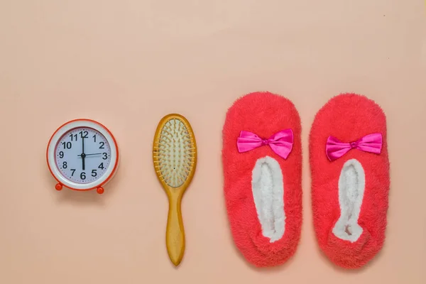 Peine de madera, despertador y zapatillas rojas sobre un fondo claro. — Foto de Stock