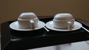 Ahşap arka planda beyaz seramik çay atau kopi fincanı. boş çay ya da sıcak kahve bardağı