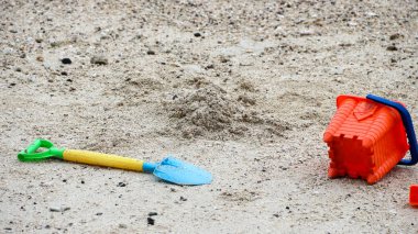 Çocuk oyuncağı kürek ve kumsaldaki plastik kova.