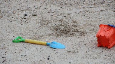 Çocuk oyuncağı kürek ve kumsaldaki plastik kova.