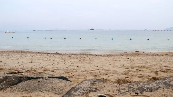 Bir dizi mavi ve beyaz şamandıra sessiz bir plajı kaplıyor. Yüzme alanlarını belirlemek için sınır işareti olarak kullanılır..