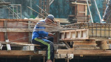 İnşaat işçileri inşaat sahasının inşaat demirini tutuyor inşaat işçileri beton yapı inşa ediyor.