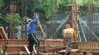 İnşaat işçileri inşaat sahasının inşaat demirini tutuyor inşaat işçileri beton yapı inşa ediyor.