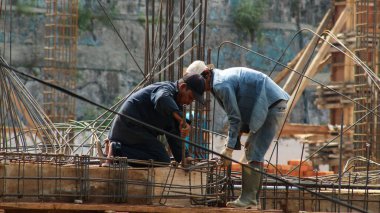 İnşaat işçileri inşaat sahasının inşaat demirini tutuyor inşaat işçileri beton yapı inşa ediyor.