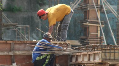 İnşaat işçileri inşaat sahasının inşaat demirini tutuyor inşaat işçileri beton yapı inşa ediyor.