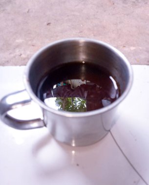 Sade bir kahve, paslanmaz çelikten bir fincanda servis edilir ve size yukarıdan getirilir..