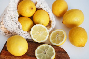 Tahtada dilimlenmiş limonlar, arka planda bir bıçağın yanında.