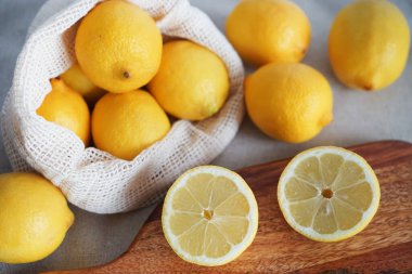 Dilimlenmiş limonlar, arka planda tahta bir tahta üzerinde.