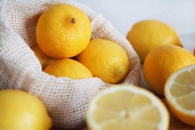 Dilimlenmiş limonlar, arka planda tahta bir tahta üzerinde.