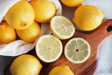 Dilimlenmiş limonlar, arka planda tahta bir tahta üzerinde.