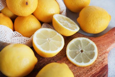 Dilimlenmiş limonlar, arka planda tahta bir tahta üzerinde.