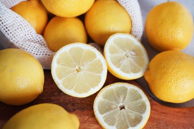 Dilimlenmiş limonlar, arka planda tahta bir tahta üzerinde.