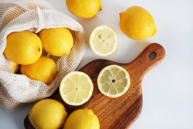 Dilimlenmiş limonlar, arka planda tahta bir tahta üzerinde.