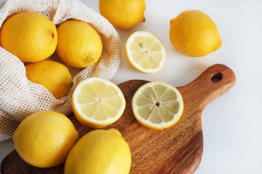 Dilimlenmiş limonlar, arka planda tahta bir tahta üzerinde.