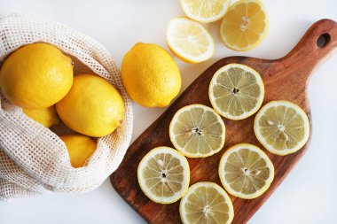 Dilimlenmiş limonlar, arka planda tahta bir tahta üzerinde.