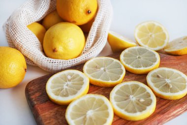 Dilimlenmiş limonlar, arka planda tahta bir tahta üzerinde.