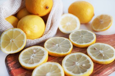 Dilimlenmiş limonlar, arka planda tahta bir tahta üzerinde.