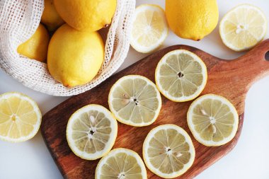 Dilimlenmiş limonlar, arka planda tahta bir tahta üzerinde.