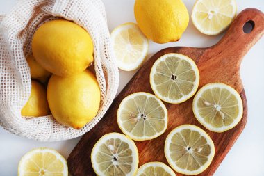 Dilimlenmiş limonlar, arka planda tahta bir tahta üzerinde.