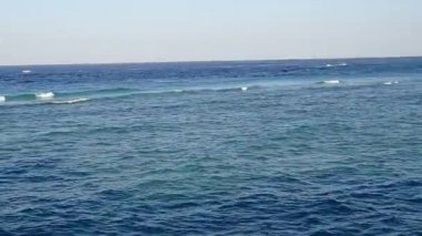 Deniz suyunun dokunduğu beyaz kumlu plajda ahşap köprü