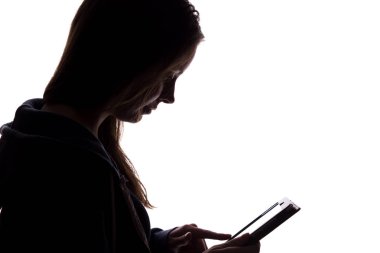 Bir tablet ile kapüşonlu bir kız silueti