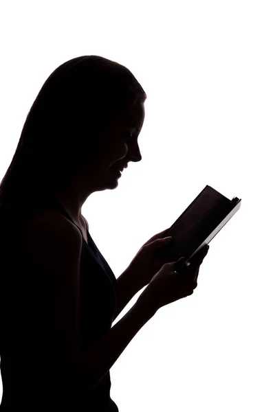 Silhuetten av en flicka med en bok — Stockfoto