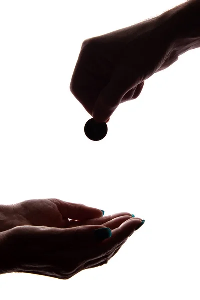 Ung mans hand med ett mynt ger allmosor-siluett, hjälp — Stockfoto