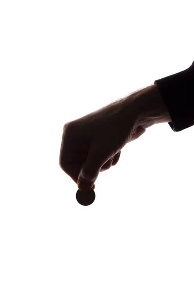 Joven mano con moneda entre los dedos - silueta, cono — Foto de Stock