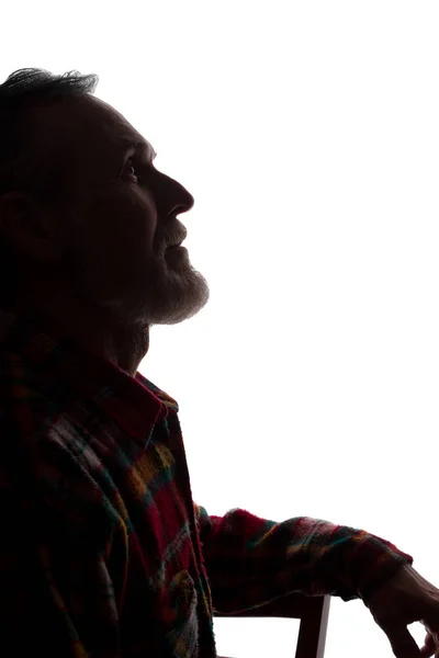 Yaşlı bir adamın portresi, yan görünüm-karanlık yakın çekim silüeti — Stok fotoğraf