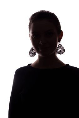 Küpeli genç kız dümdüz ileriye bakıyor, portre silueti izole ediyor