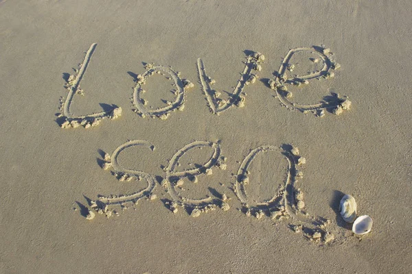 Lettering love sea on sand sunrise background sea, beach dawn
