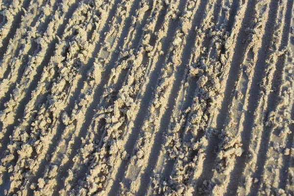 Ίχνη από γρατσουνιές στην άμμο Ανατολή του ηλίου φόντο θάλασσα, υφή — Φωτογραφία Αρχείου