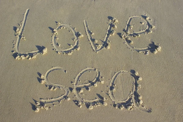 Belettering liefde zee op zand Sunrise achtergrond zee, strand Dawn — Stockfoto