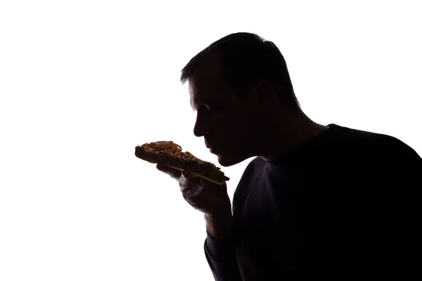 Porträt junger Mann isst Pizza, zufrieden, Seitenansicht - Silhouette — Stockfoto