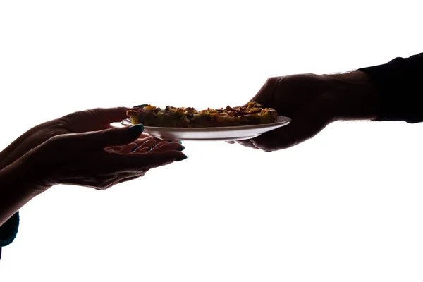 Young man gives a pizza on dish - silhouette, help concept — Stock Photo, Image