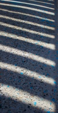 Beton bir arka planda çizgili gölgeler - c