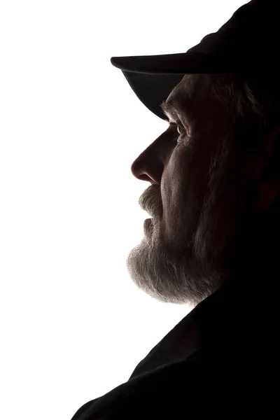 Old man in peaked cap, side view - dark close-up silhouette — Stock Photo, Image