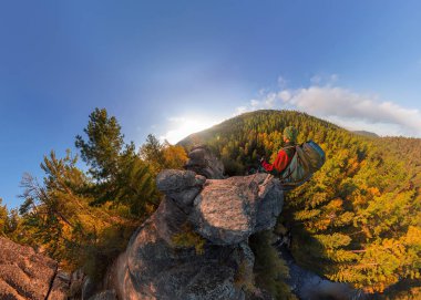Backpacker bir kaya üzerine düşmek şafakta. Geniş açı hava panorama