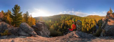 Backpacker bir kaya üzerine düşmek şafakta. Silindirik panorama 360 derece.
