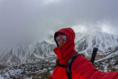 Bir sırt çantası ile bir miğfer Selfi erkek dağcı karlı dağlarda.