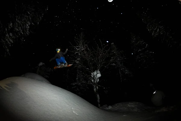 Фрирайдер ездит ночью на порошковом снегу взрывается — стоковое фото