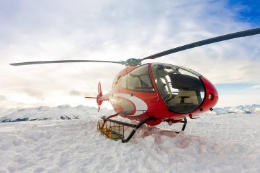 Kırmızı kurtarma helikopteri ayakta karlı dağlarda toprakları.